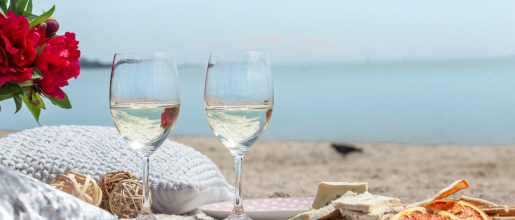 wine glasses in front of the private beach of long bay beach club